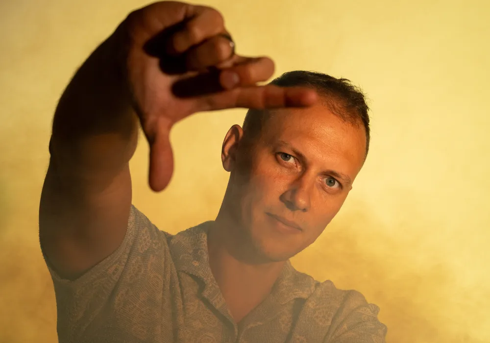 Artur Schmidt rahmt mit beiden Händen einen Bildausschnitt